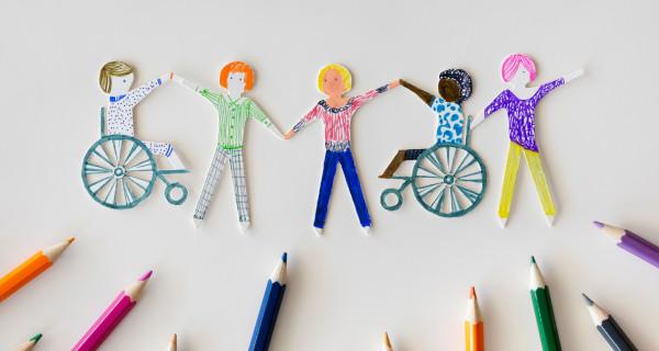 Paper cutout people holding hands with three standing and two in wheelchairs